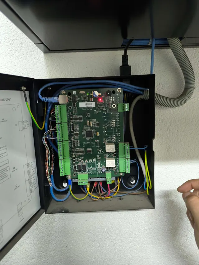 Otvorena kutija sa Hikvision kontrolerom pristupa i spojenim kablovima
