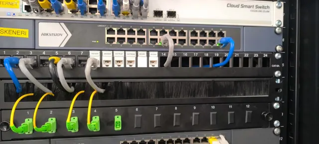 Detalj reka: označene utičnice patch panela, Hikvision switch i optički priključci